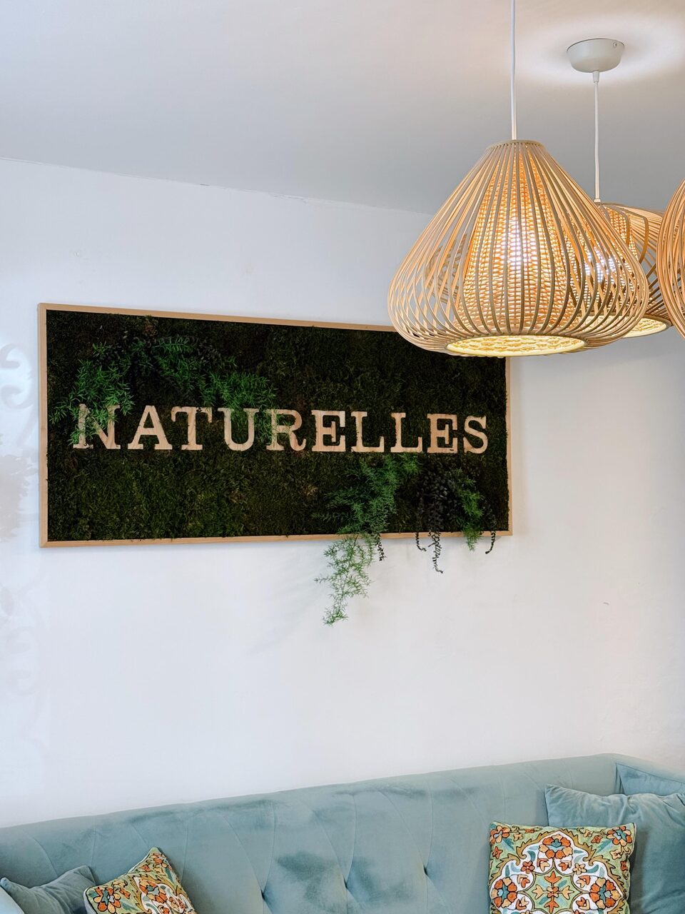 L'enseigne Naturelles en mousse végétale au-dessus de la banquette d'accueil