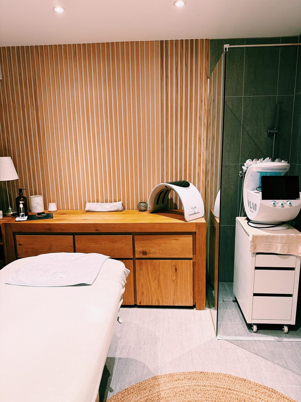 Cabine au mur de bois cannelé, table de soin et appareil de vapeur pour le visage