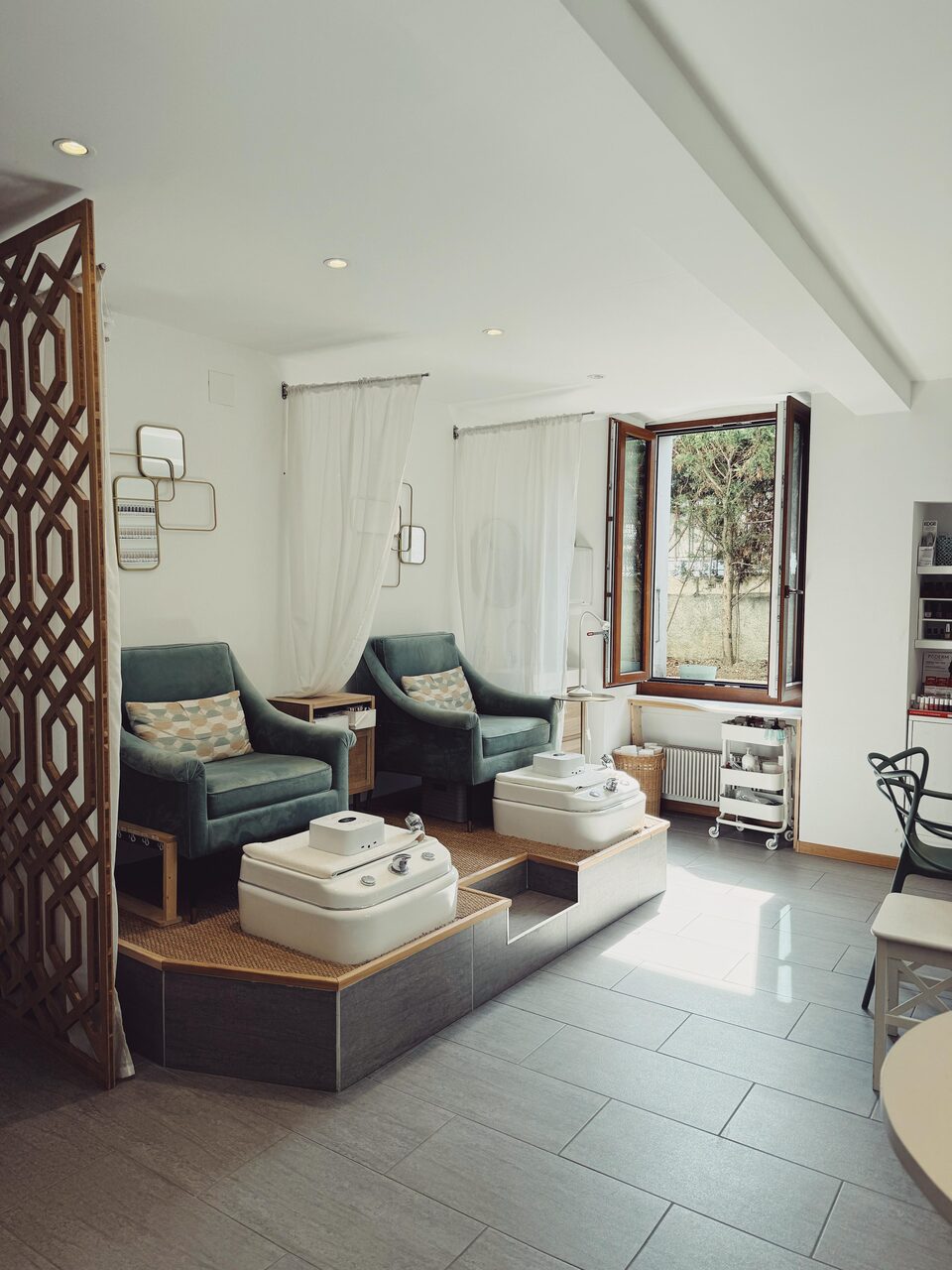 L'espace beauté des pieds, claustra en bois et fauteuils face aux fenêtres